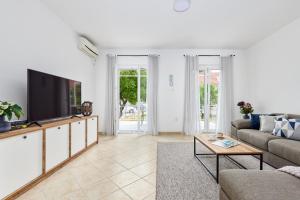 a living room with a couch and a tv at Waikiki Beach House in Tivat