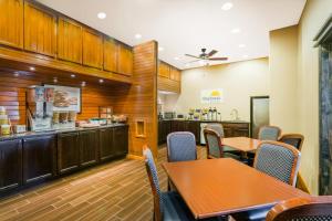 a kitchen with a table, chairs and a refrigerator at The Inn At Plantation in Weston