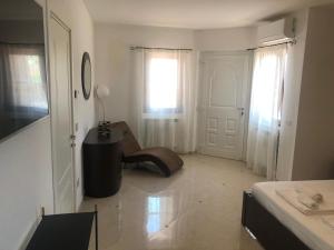 Habitación blanca con cama, silla y puerta en Villa Carmen Resort, en Campobasso