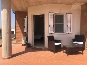 a patio with two chairs and a table and a window at Villa Carmen Resort in Campobasso
