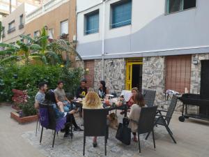 un grupo de personas sentadas alrededor de una mesa en un patio en LA PITA BEACH HOUSE, en Almería