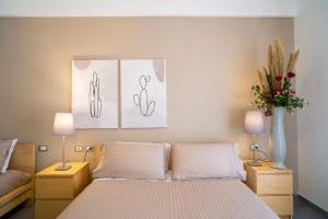 a bedroom with a bed with two tables and two lamps at Enny Camere in Alcamo