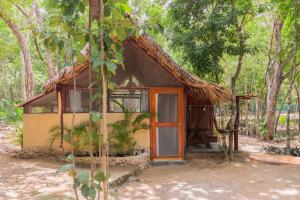 a small house with a thatch roof at MELI-MELO P&B in Tulum