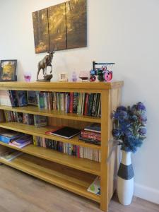 a book shelf filled with books and a vase of flowers at Bankhouse B&B in Aberlour