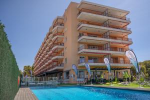 a hotel with a swimming pool in front of a building at Albatros Family in Salou