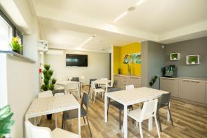 una sala da pranzo con tavoli e sedie bianchi di Onda Boutique Hotel a Mamaia Nord - Năvodari