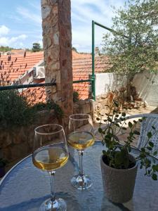 two glasses of white wine sitting on a table at Apartments Lošotovi Vrboska in Vrboska