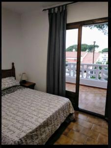 een slaapkamer met een bed en een glazen schuifdeur bij Casa katy in L'Escala