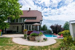 a house with a swimming pool in the yard at La Villa Du Coteau in Obernai