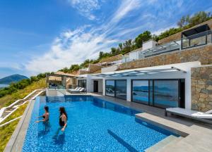 a house with a swimming pool with two women standing in it at Desun Suites in Kolónion