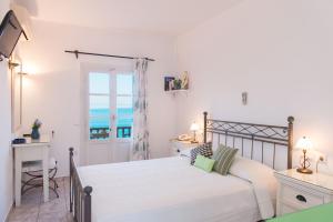1 dormitorio con cama y vistas al océano en Hotel Efrosini, en Platis Yialos Sifnos