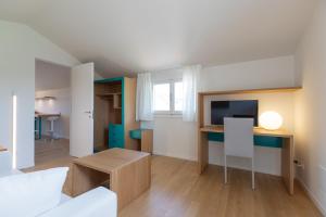 ein Wohnzimmer mit einem Schreibtisch und einem TV in der Unterkunft La Colombiera Relais in Castelnuovo Magra