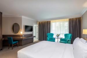 a hotel room with a bed and a desk and chairs at Hotel Kilmore in Cavan +79 photos