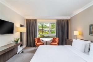 une chambre d'hôtel avec un lit, une table et des chaises dans l'établissement Hotel Kilmore, à Cavan