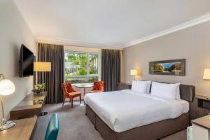 um quarto de hotel com uma cama grande e uma escrivaninha em Hotel Kilmore em Cavan