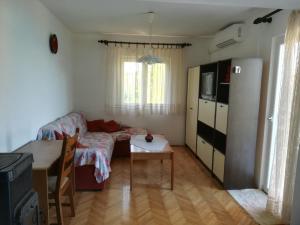 uma sala de estar com um sofá e uma mesa em Apartment Porat em Ugljan