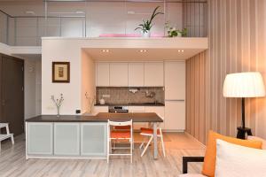 an open kitchen and dining room with a table and chairs at Apartamentai Šviesa in Palanga