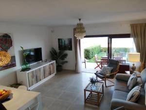 uma sala de estar com um sofá e uma televisão em Apt playa de Muro ca n Ines - 1ª linea de playa em Port d'Alcudia