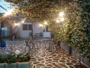 eine Terrasse mit einem Tisch und Stühlen auf einem Steinboden in der Unterkunft Green house - Apartment in Aridaia-Loutra Pozar in Aridea