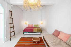 1 dormitorio con cama, escalera y sofá en La Cayena Rooms, en Ciutadella
