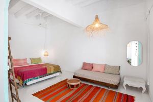 a white room with two beds and a couch at La Cayena Rooms in Ciutadella