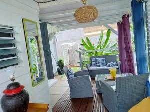 ブイヤントにあるVilla élégante à Bouillante avec piscine privéeのパティオ(ガラスのテーブル、ポーチチェア付)