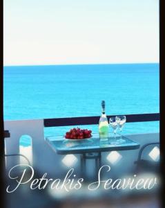 una mesa con una botella de vino y dos copas en Petrakis Sea View, en Palaiochóra