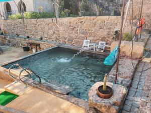 a swimming pool with two chairs in a stone wall at Casa do Convento in Arcos de Valdevez