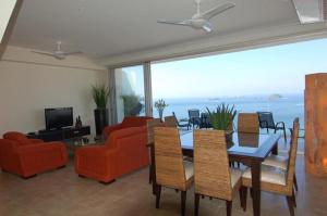 a living room with a table and chairs and a couch at Beachfront PH Amara Ixtapa in Ixtapa