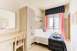 a small bedroom with a bed and a window at Hotel Vela d'Oro in Rimini