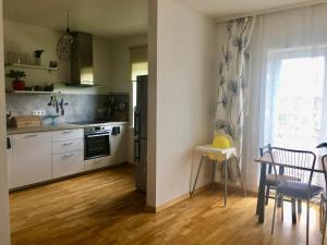 a kitchen with white appliances and a table and chairs at Strelnieku Apartment in Sigulda