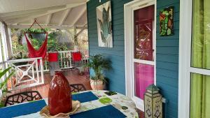 un jarrón sentado en una mesa en un porche en Bungalow de 2 chambres a Bouillante a 100 m de la plage avec vue sur la mer jardin amenage et wifi, en Bouillante