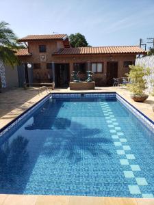 uma piscina em frente a uma casa em Suítes Verano Ubatuba - Bairro Itaguá - com piscina em Ubatuba