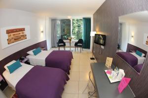 a hotel room with two beds and a table at Altius Boutique Hotel in Nicosia