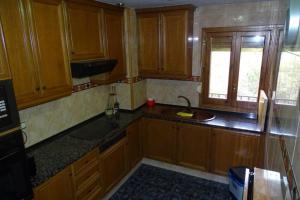 cocina con armarios de madera, fregadero y ventana en Apartamento rural en Los Pirineos, en Guardiola de Berguedà