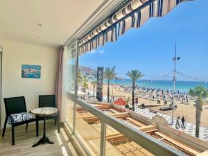 a room with a balcony with a view of the beach at Gemelos 1 Modern Seaviews in Benidorm