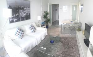 uma sala de estar com um sofá branco e uma mesa em Gemelos 28 Levante Seaview em Benidorm