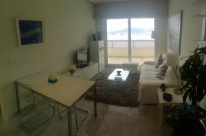 uma sala de estar com um sofá e uma mesa em Gemelos 28 Levante Seaview em Benidorm