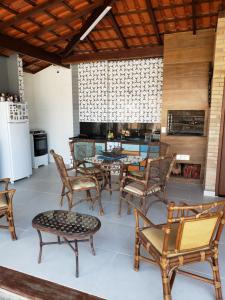 um pátio com mesa e cadeiras e uma cozinha em Suítes Verano Ubatuba - Bairro Itaguá - com piscina em Ubatuba