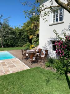 a patio with a table and chairs next to a house at Maison d'Hôtes Joussaume Latour in Château-Thierry