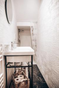 een badkamer met een wastafel en een mandje toiletpapier bij Casa Nenè in Otranto +12 foto's