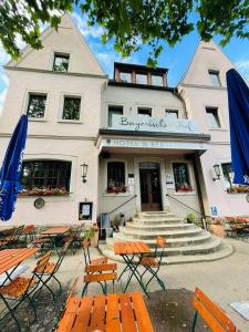 ein Hotel mit Tischen und Stühlen vor einem Gebäude in der Unterkunft Bayerischer Hof in Rothenburg ob der Tauber