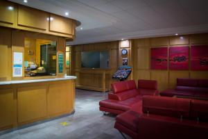 a waiting room with red couches and a bar at Hotel El Senador in Mexico City