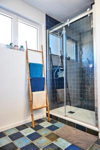 a bathroom with a glass shower and a chair at CHARNER centre gare 2 chambres 100m2 parking in Saint-Brieuc