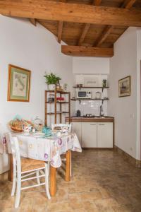 een keuken met een tafel en stoelen en een keuken met een aanrecht bij B&B Etruscan Garden in Sutri