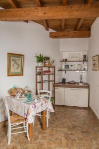 een keuken met een tafel en stoelen en een keuken met een aanrecht bij B&B Etruscan Garden in Sutri