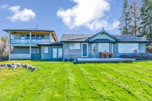 een blauw huis met een grote tuin ervoor bij @ Marbella Lane - Waterfront Studio Whidbey Island in Coupeville