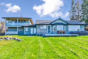 a blue house with a large yard in front of it at @ Marbella Lane - Waterfront Studio Whidbey Island in Coupeville