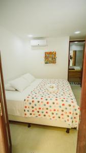 a bedroom with a white bed with a flower pattern at Pousada ResDelMar in Baía Formosa