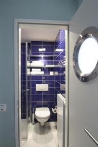 a bathroom with a toilet, sink and mirror at Havelhotel in Brandenburg an der Havel